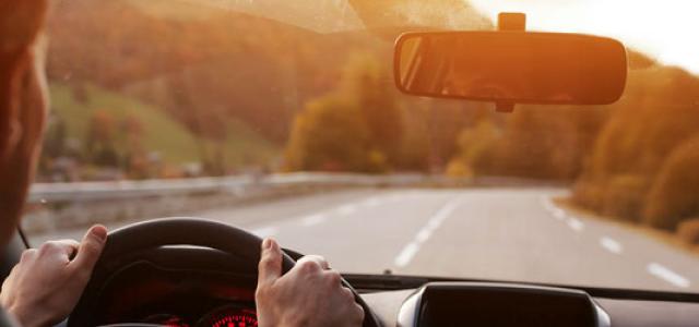 driver looking forward towards the road with their eyes reflected in the rearview mirror